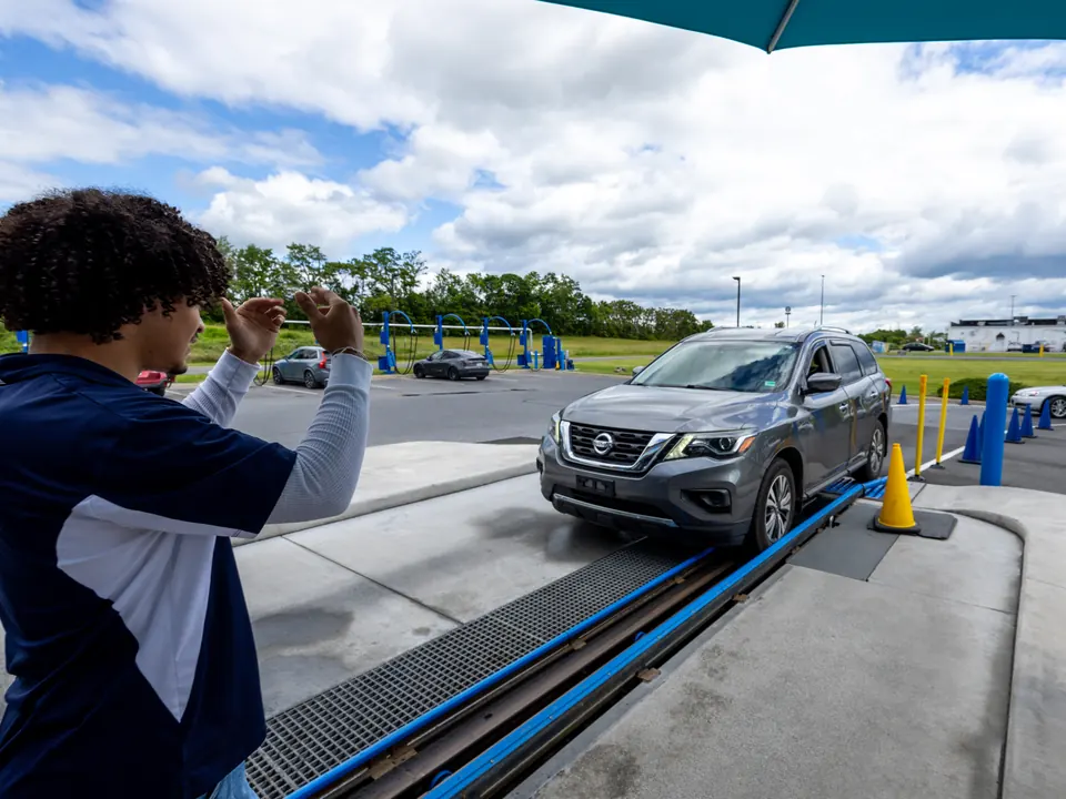 Woodstock Car Wash team member guiding a car into the express tunnel